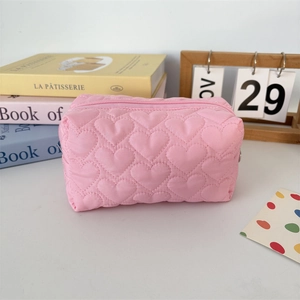 Close-up of pink quilted makeup bag with heart patterns and premium zipper closure