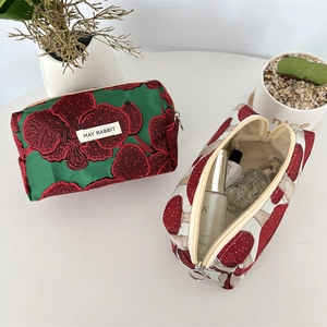 Détail de la pochette en jacquard floral et de l'organisateur à motif de champignons