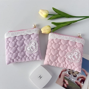 Macro detail of quilted heart pattern lace coin pouch with elegant pearl zipper head