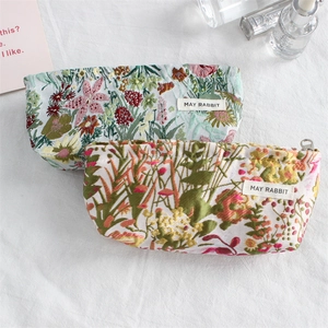 Close-up of floral embroidery on high-density canvas cosmetic bags with metal zippers