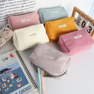 Close-up of colorful corduroy bags with zipper and May Rabbit brand label in six colors