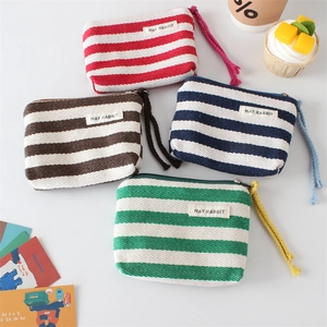 Close-up of colorful striped canvas coin purses with woven labels and zipper pulls