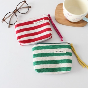 Detail of striped canvas coin purses with fabric label and colorful zipper pulls