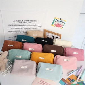 Detailed close-up of colorful corduroy storage bags with texture and woven brand labels