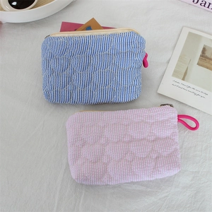 Detail of heart quilted cotton pouches with red ring zippers in stripes and gingham