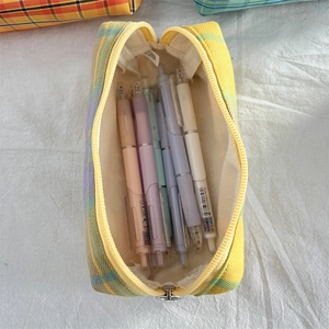 Macro view of checkered pencil case interior showing spacious capacity with stationery