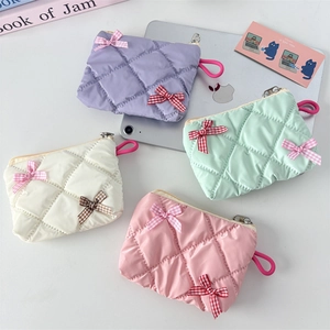 Quilted cosmetic bags in pastel colors with bow decoration and metal zipper details