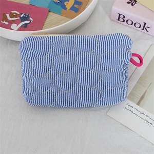 Close-up of heart quilted blue striped pouch with a vibrant pink rope handle detail