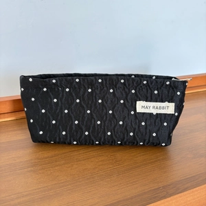 Detail showing black polka dot makeup bag fabric texture and May Rabbit cotton brand label