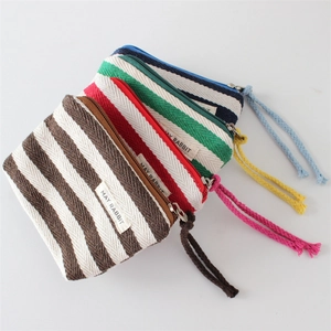Detail of four colorful striped canvas mini pouches with zippers and wrist straps