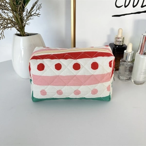 Close-up of quilted cotton cosmetic bag with colorful stripes and polka dot patterns