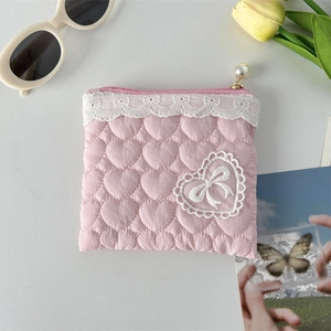Detail of pink quilted heart pouch with lace trim and white pearl zipper slider