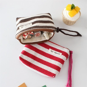 Detail of striped canvas pouch interior showing capacity for lipstick and makeup items