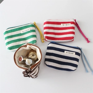 Macro shot of four colorful striped canvas mini pouches with zippered storage detail