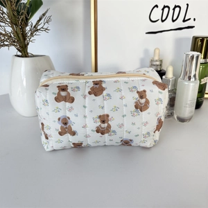 Detailed macro of the soft quilted texture and cute bear floral patterns on the cosmetic bag