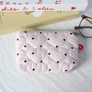 Pink heart quilted coin pouch with polka dots and zipper on a white fabric background