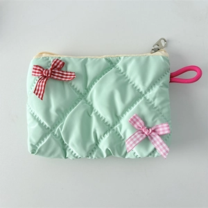 Detail of mint green quilted makeup bag with gingham bows and pink lanyard handle