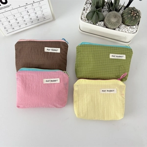 Flat lay of four colorful checkered nylon organizers with zip closures on white background