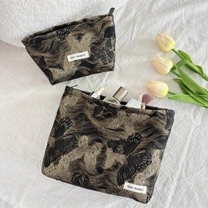 Detail of butterfly pattern cosmetic bags set with makeup brushes and skincare storage