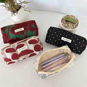 Vue à plat de trousses en jacquard aux motifs de champignons et fleurs sur bureau