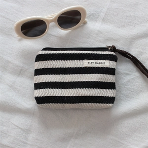 Detail of striped fabric coin purse with durable zipper and woven wrist strap