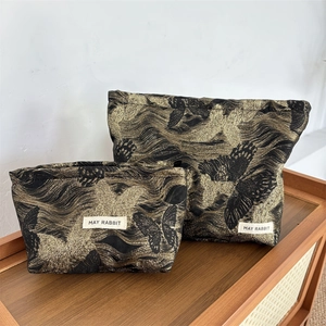 Detailed embroidery of gold butterflies on high-capacity black makeup bags in two sizes