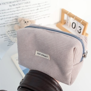Detail of soft corduroy fabric texture and zipper closure on the purple storage pouch