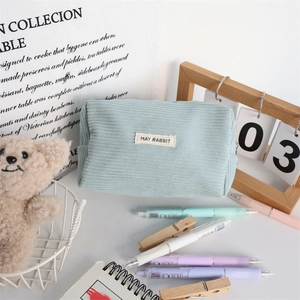 Detail of light blue corduroy pouch with May Rabbit label and soft textured fabric