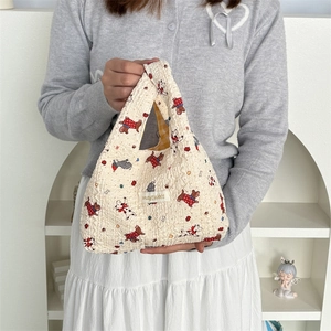 Detailed close-up of cream puffy embossed handbag with cute cartoon dog and mayrabbit label