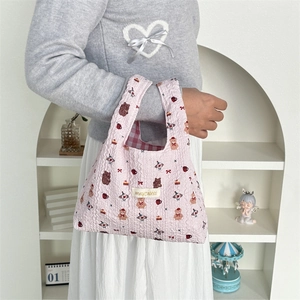 Detail of pink quilted tote bag featuring cute cartoon bears and soft cotton texture
