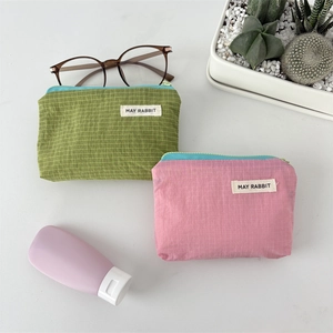 Close-up of green and purple checkered nylon pouches with zipper and May Rabbit label