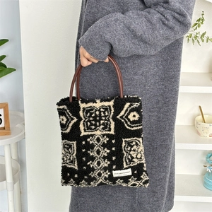 Plush retro tote bag with black and white geometric patterns and brown top handles