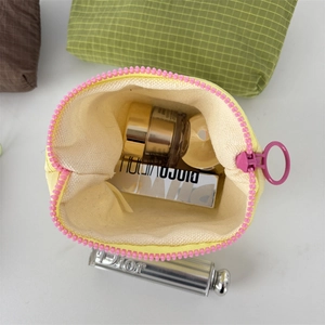Detail view of yellow nylon checkerboard cosmetic bag with pink zipper and open interior