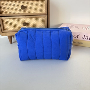 Macro shot of bright blue quilted nylon texture and zipper detail of the makeup bag