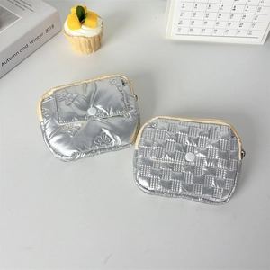 Detail of silver quilted PU coin purses with floral and checkerboard textured patterns