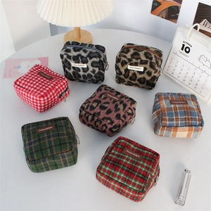 Détails de diverses trousses à maquillage en tweed aux motifs léopard et carreaux