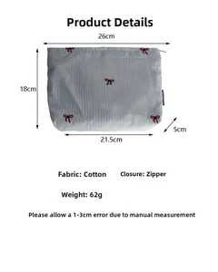 Detail view of cotton striped cosmetic bag with bow embroidery and 26x18x5cm dimensions
