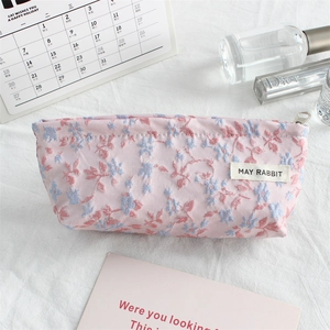 Detail of floral embroidery on pink canvas pouch with silver metal zipper closure