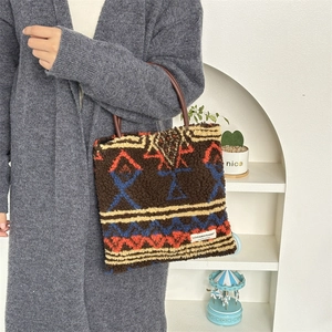 Detail of plush brown tote bag with geometric ethnic pattern and leather handles