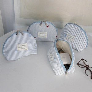 Detail of blue striped and checkered shell makeup bags showing interior storage capacity
