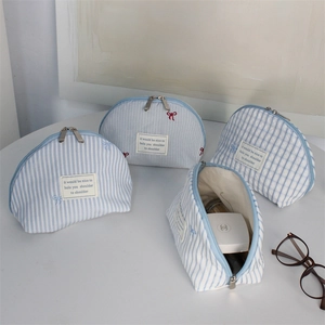 Set of four striped and plaid shell-shaped makeup bags with embroidery and zippers