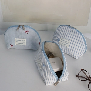 Detail of light blue embroidered bow canvas cosmetic bags with stripes and checkers