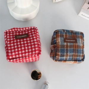 Vue à plat de pochettes carrées en tweed à carreaux vintage avec logo en cuir marron et accessoires