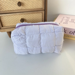 Close-up of quilted light purple makeup bag with soft texture and zip closure detail
