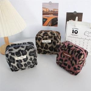 Lot de trois trousses à maquillage en peluche léopard en gris, marron et rose