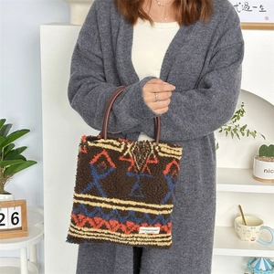 Detail of plush brown tote bag with colorful ethnic patterns and leather handles