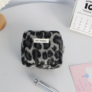 Détail macro de la trousse en laine léopard avec l'étiquette MAY RABBIT et la fermeture
