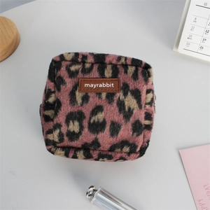 Vue détaillée d'une trousse de maquillage pelucheuse à motif léopard rose avec étiquette