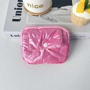Close-up of pink heart-quilted PU coin purse with metallic gloss and snap button detail