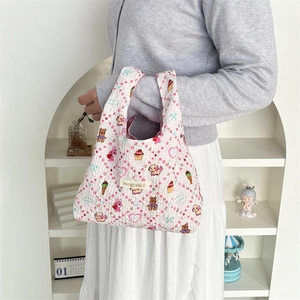 Detail of floral bubble embossed handbag featuring cute cartoon prints and branded woven tag